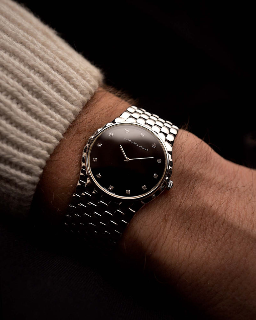 Montre Audemars Piguet Cobra vintage en or blanc 18 carats, cadran en diamants noirs, mécanisme manuel, bracelet intégré sur fond noir, vidéo disponible.