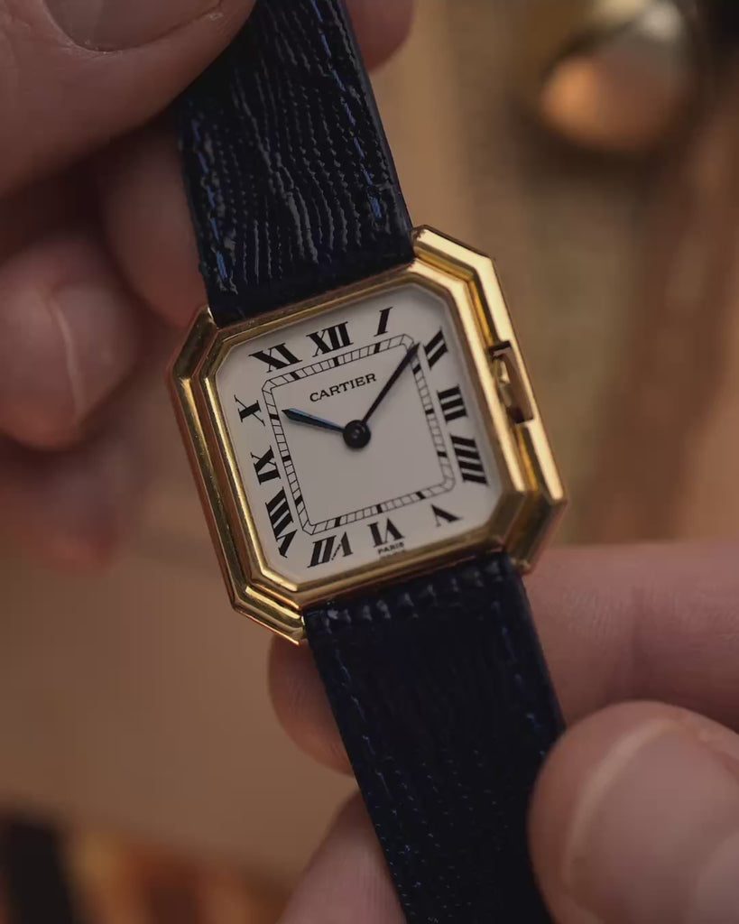Montre vintage Cartier Ceinture 78099 avec boîtier carré en or jaune 18 carats, cadran blanc, remontage manuel, bracelet en cuir bleu sur fond flou, vidéo des détails.