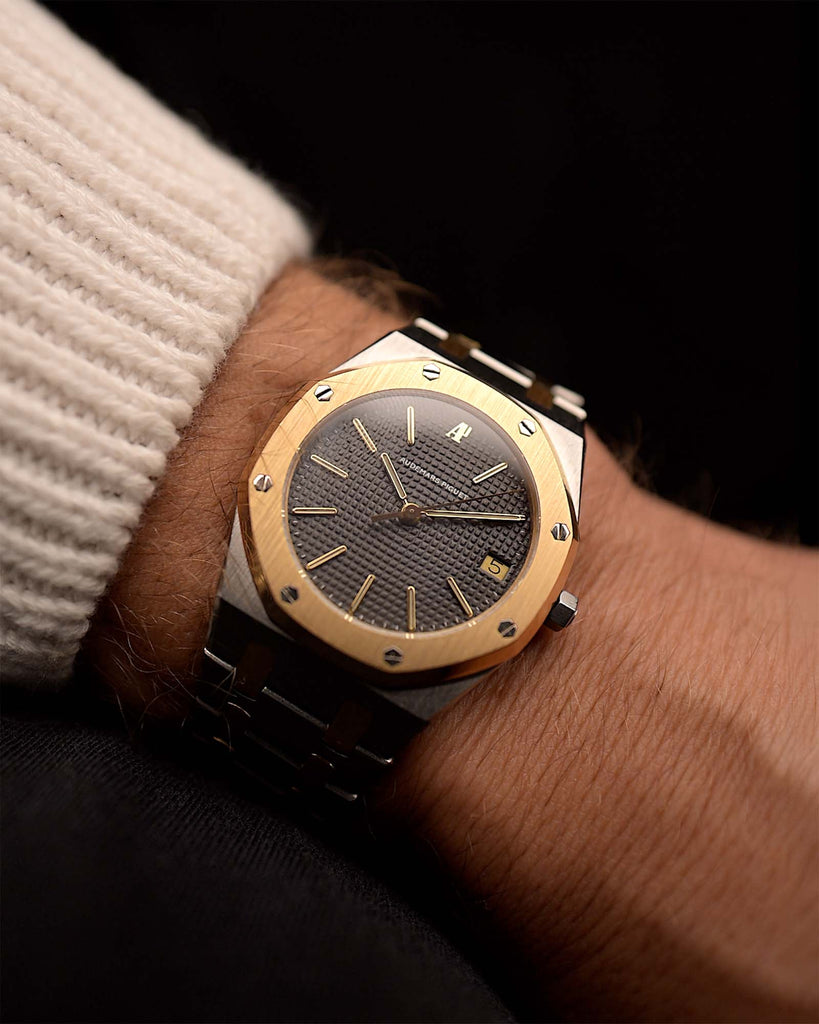 Montre Audemars Piguet 4100SA Royal Oak des années 1980 sur un poignet. 36mm en acier inoxydable et or jaune 18k avec cadran en tapisserie grise, bracelet bicolore et mouvement automatique.