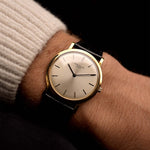 Montre vintage Patek Philippe 3520 Calatrava 18k des années 1970 sur un poignet. 32.5mm avec boîtier en or jaune 18k, calibre manuel 175, cadran argenté Sunburst impeccable et bracelet en cuir d'origine.