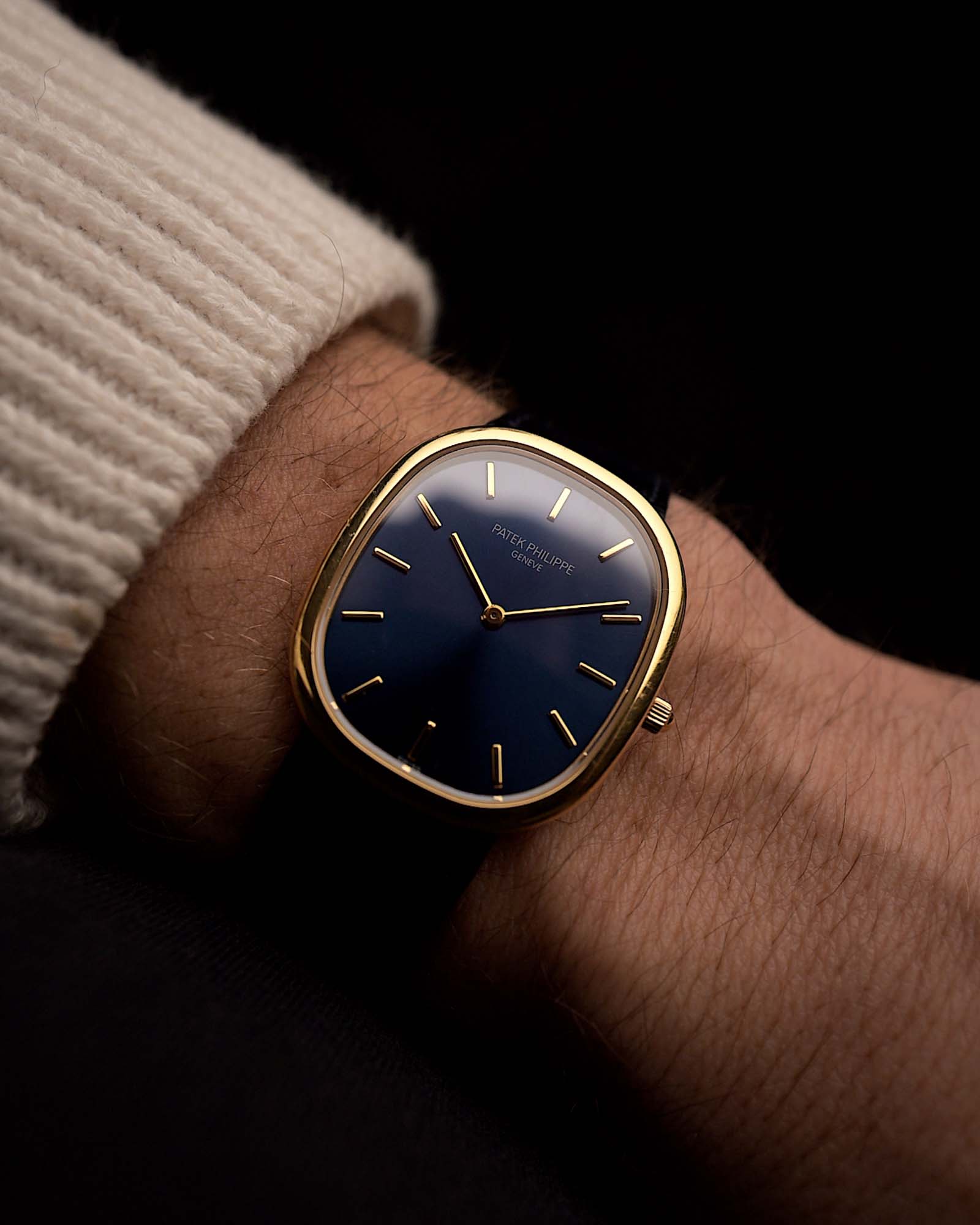 Montre vintage Patek Philippe 3738 Ellipse Jumbo, en or jaune 18 carats, cadran bleu, automatique, bracelet en cuir bleu sur un poignet sur fond noir, vidéo