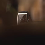 Montre Omega Rectangular Syringe vintage, cadran noir doré, boîtier en acier inoxydable, mouvement manuel, sur bracelet en cuir noir, fond flou, vidéo