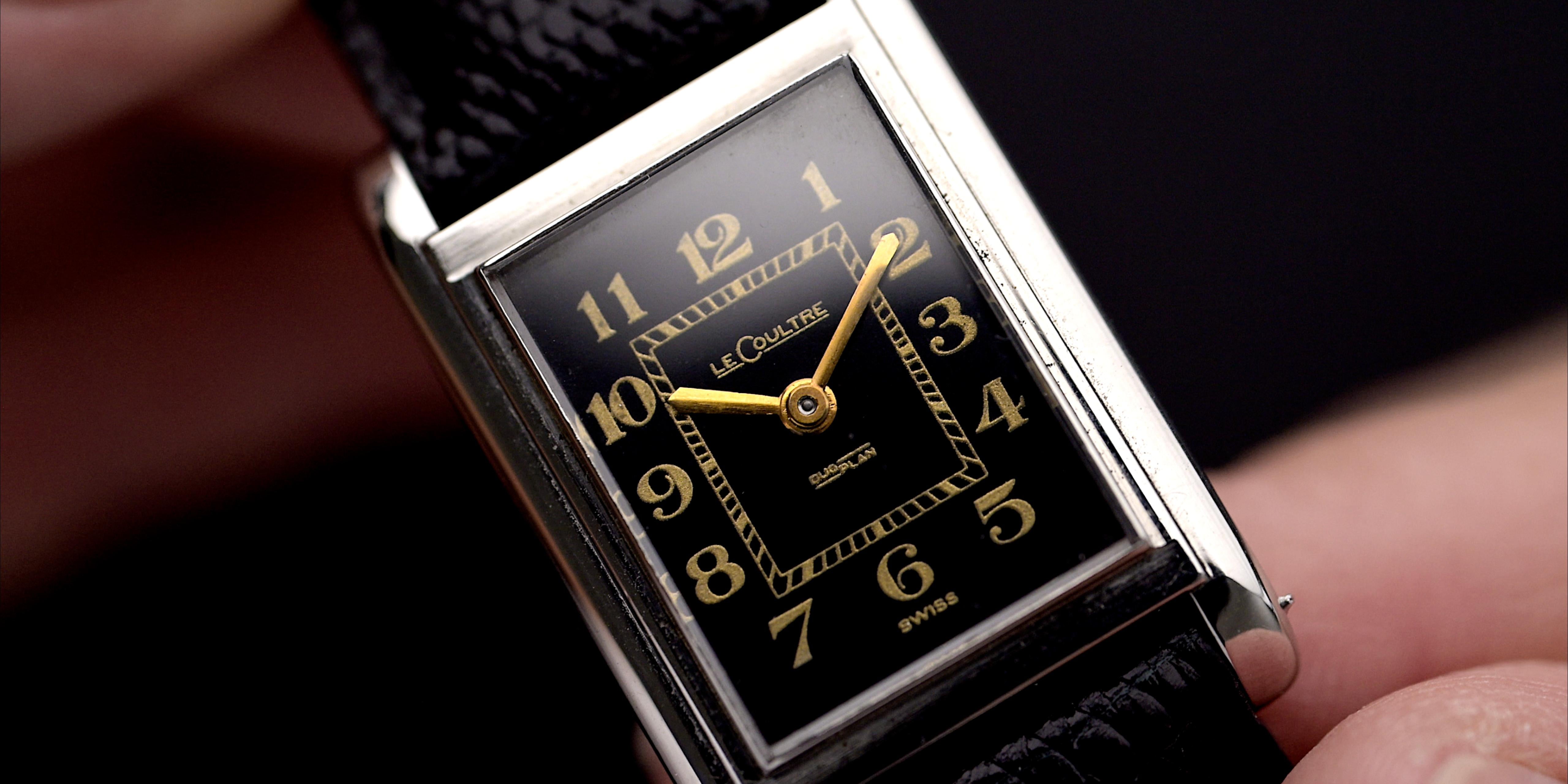 Primo piano del quadrante di un LeCoultre vintage degli anni '40 con quadrante nero, numeri Breguet e movimento Duoplan