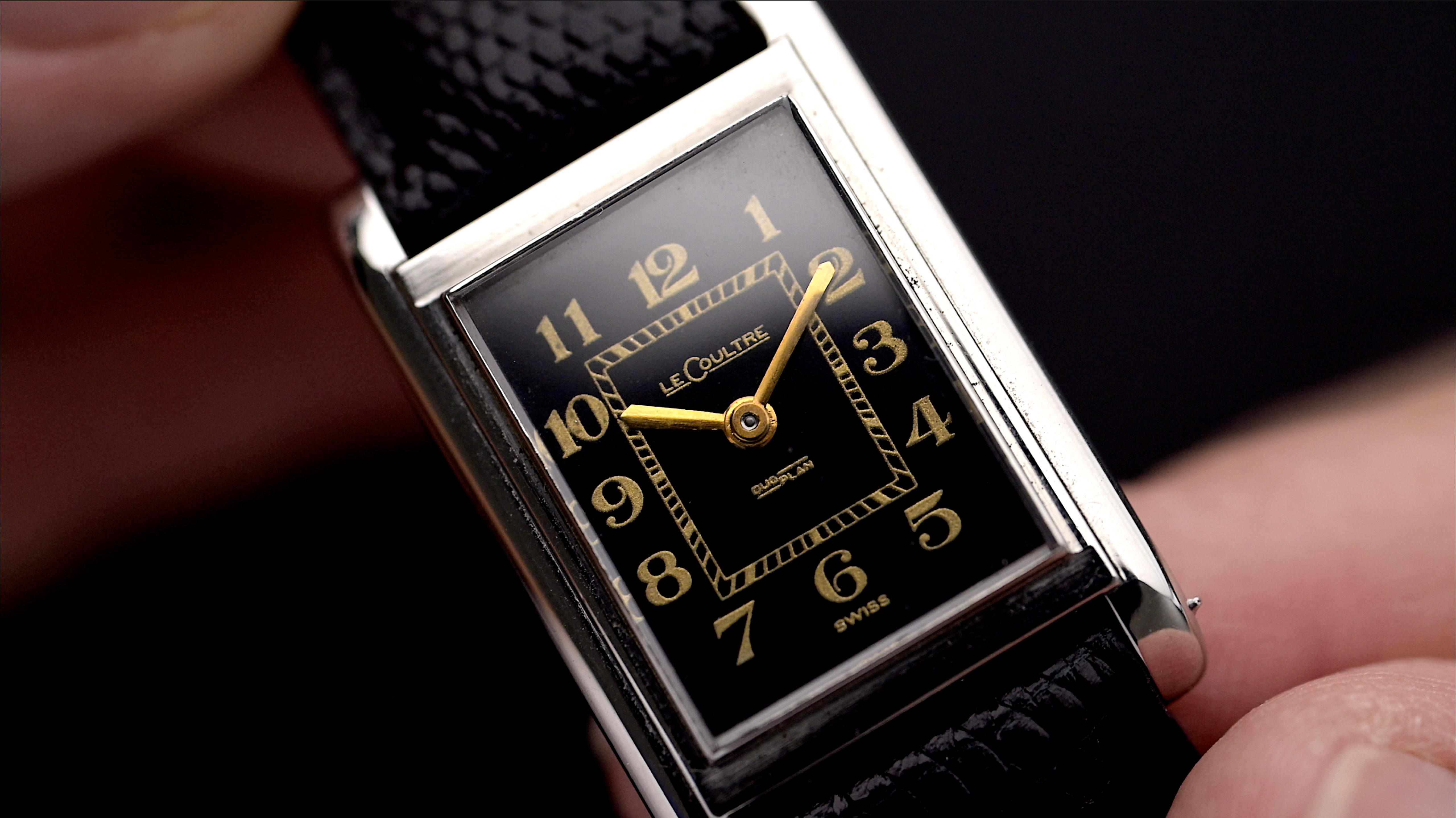Primo piano del quadrante di un LeCoultre vintage degli anni '40 con quadrante nero, numeri Breguet e movimento Duoplan