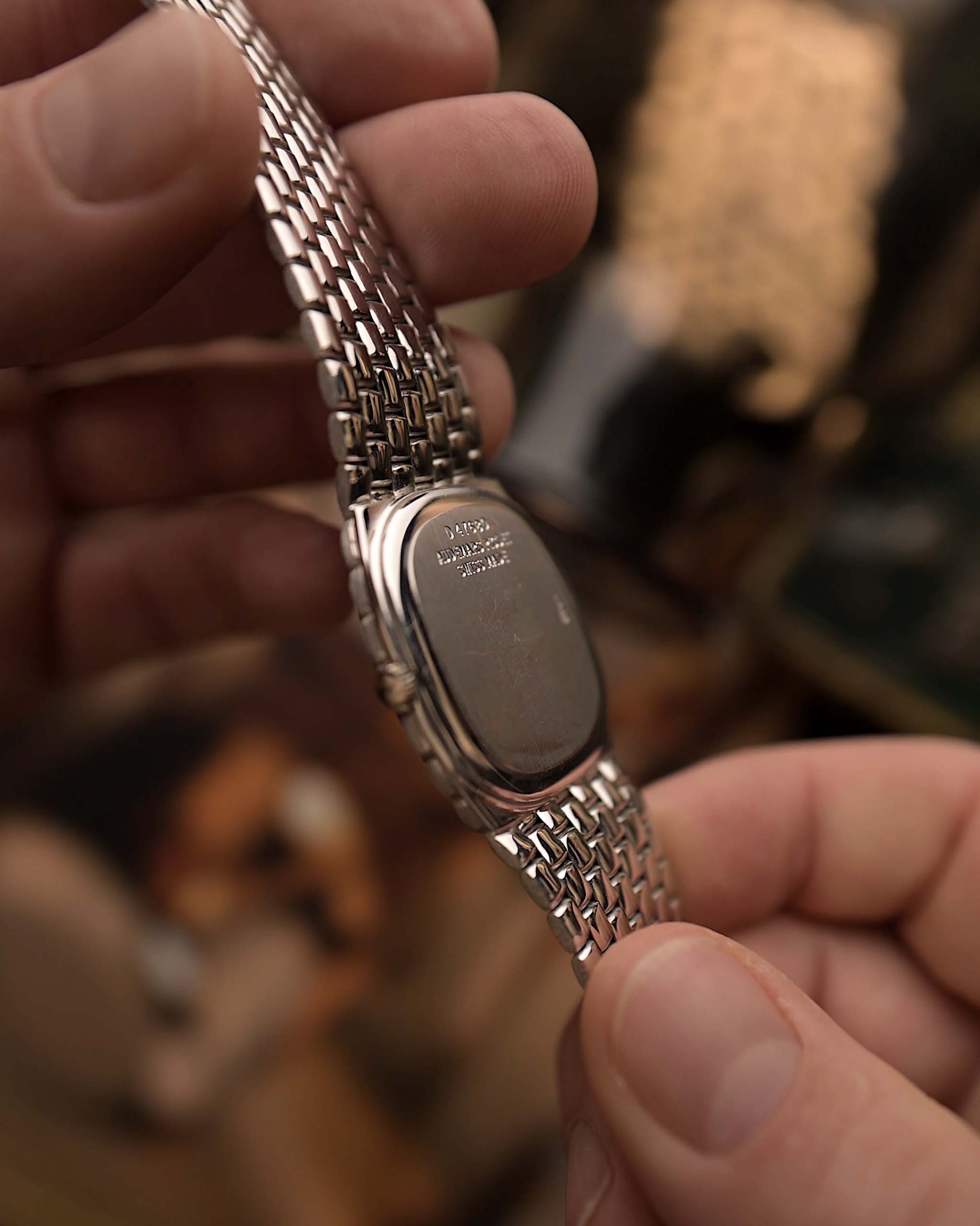 Primo piano di un orologio Audemars Piguet Cobra vintage con fondello in oro bianco 18 carati, bracciale in oro bianco, tenuto in mano con uno sfondo sfocato