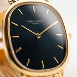 Foto ravvicinata di un Patek Philippe Ellipse 3738 Jumbo del 1998 al polso. Con movimento automatico, cassa di 31 mm, 27 rubini, quadrante originale blu a raggiera, bracciale in oro giallo.