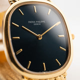 Foto ravvicinata di un Patek Philippe Ellipse 3738 Jumbo del 1998 al polso. Con movimento automatico, cassa di 31 mm, 27 rubini, quadrante originale blu a raggiera, bracciale in oro giallo.