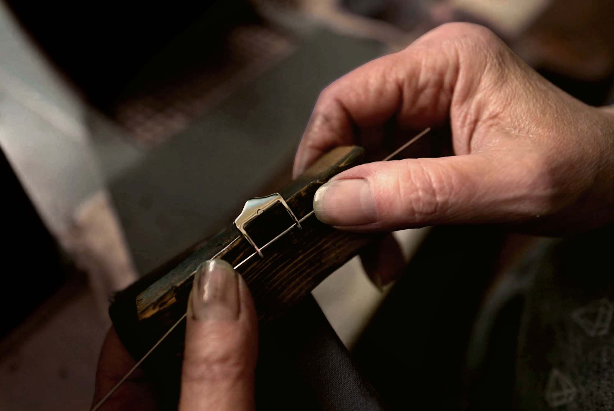 Fissare a mano la fibbia al cinturino dell'orologio in pelle.