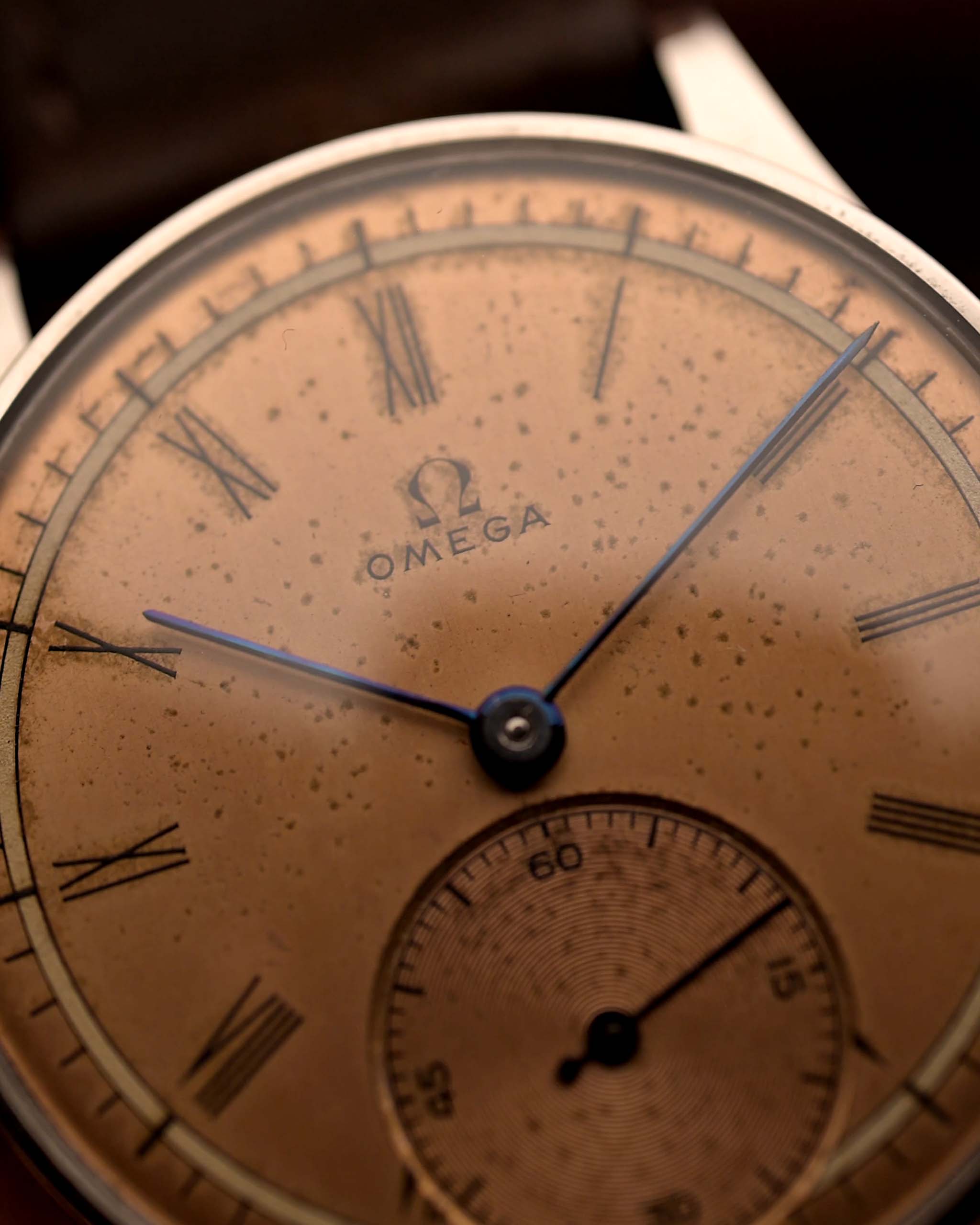 Primo piano di un Omega Art Deco Roman Sub Second 1939 Orologio Vintage in acciaio con quadrante salmone con patina