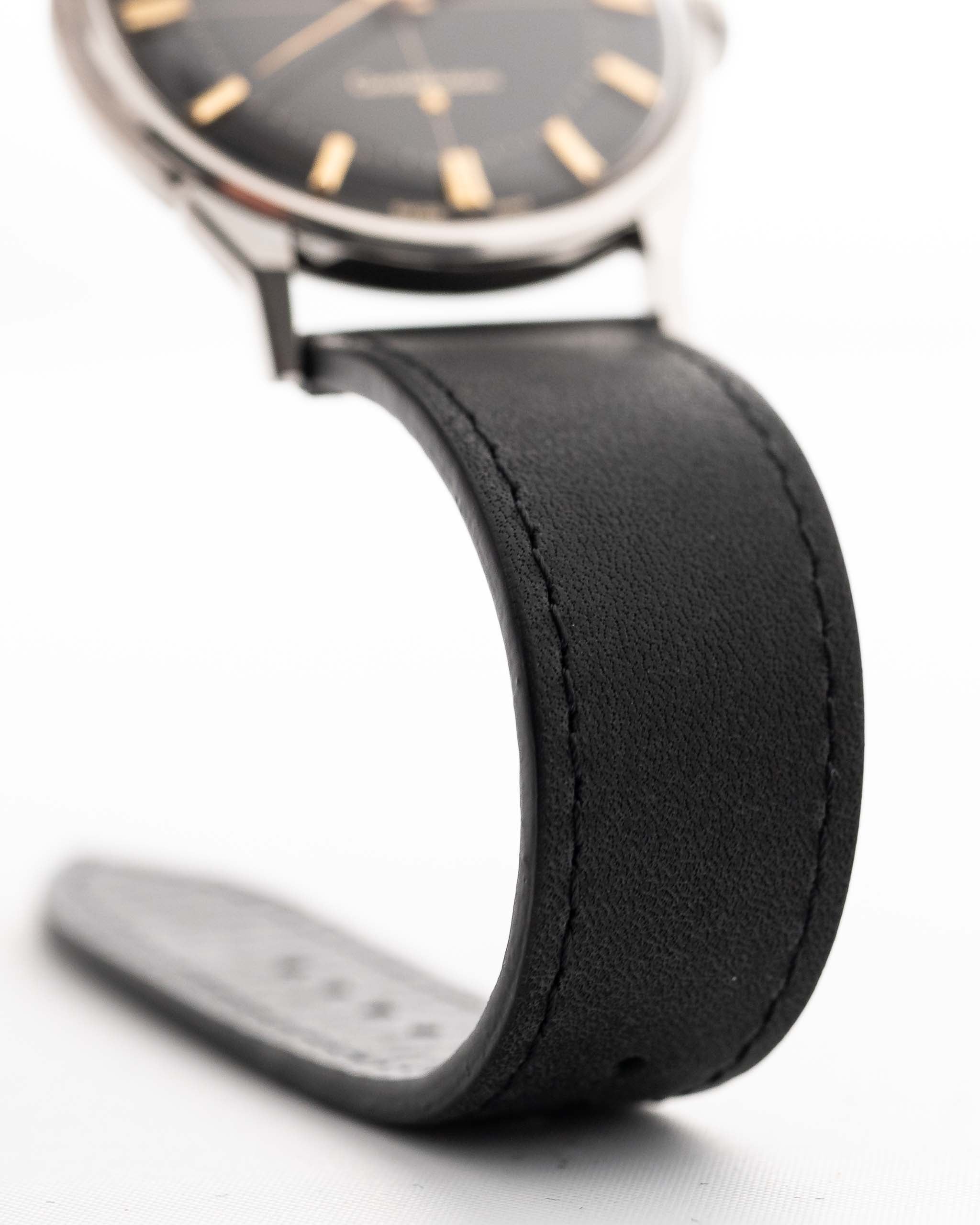 Foto ravvicinata di un Omega Constellation 14900 Pie Pan Black del 1961. Cassa in acciaio da 34 mm con cronometro automatico Calibro 551, quadrante pie pan nero originale e cinturino in pelle.