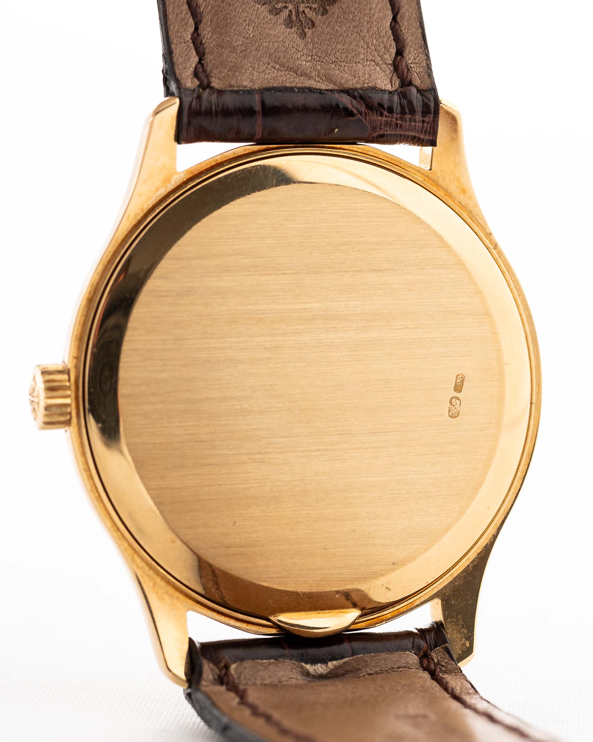 Primo piano di una cassa vintage Patek Philippe 3923 Calatrava degli anni Novanta. 32 mm in oro giallo 18 carati con movimento a carica manuale, quadrante Sigma, cinturino in pelle originale e fibbia in oro 18 carati.