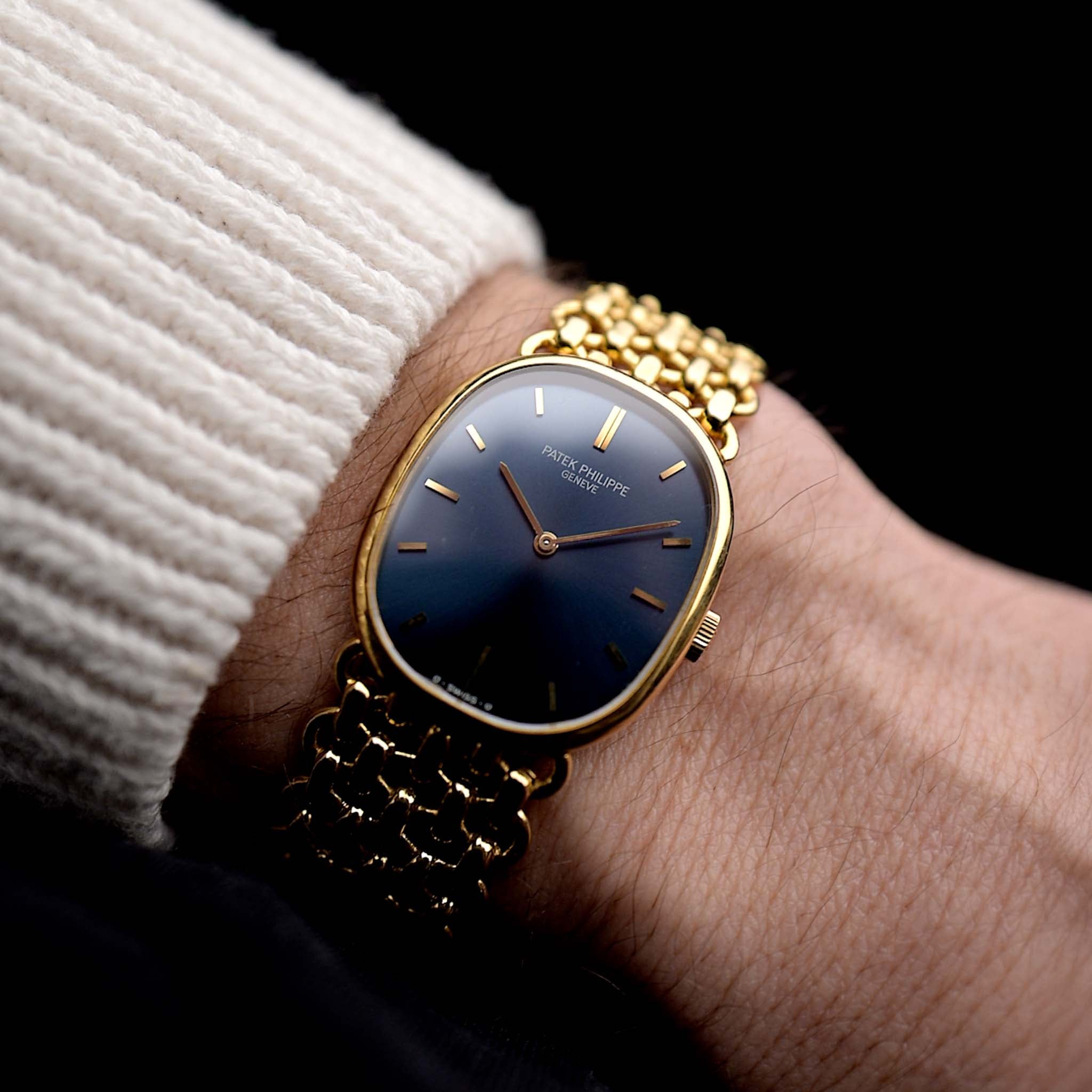 Foto di un Patek Philippe Ellipse 3648 d'Or 18k Blue degli anni '70 al polso. Cassa di 27 mm in oro giallo con carica manuale Cal. 23-300, quadrante blu a raggiera e bracciale a maglie d'oro integrato.
