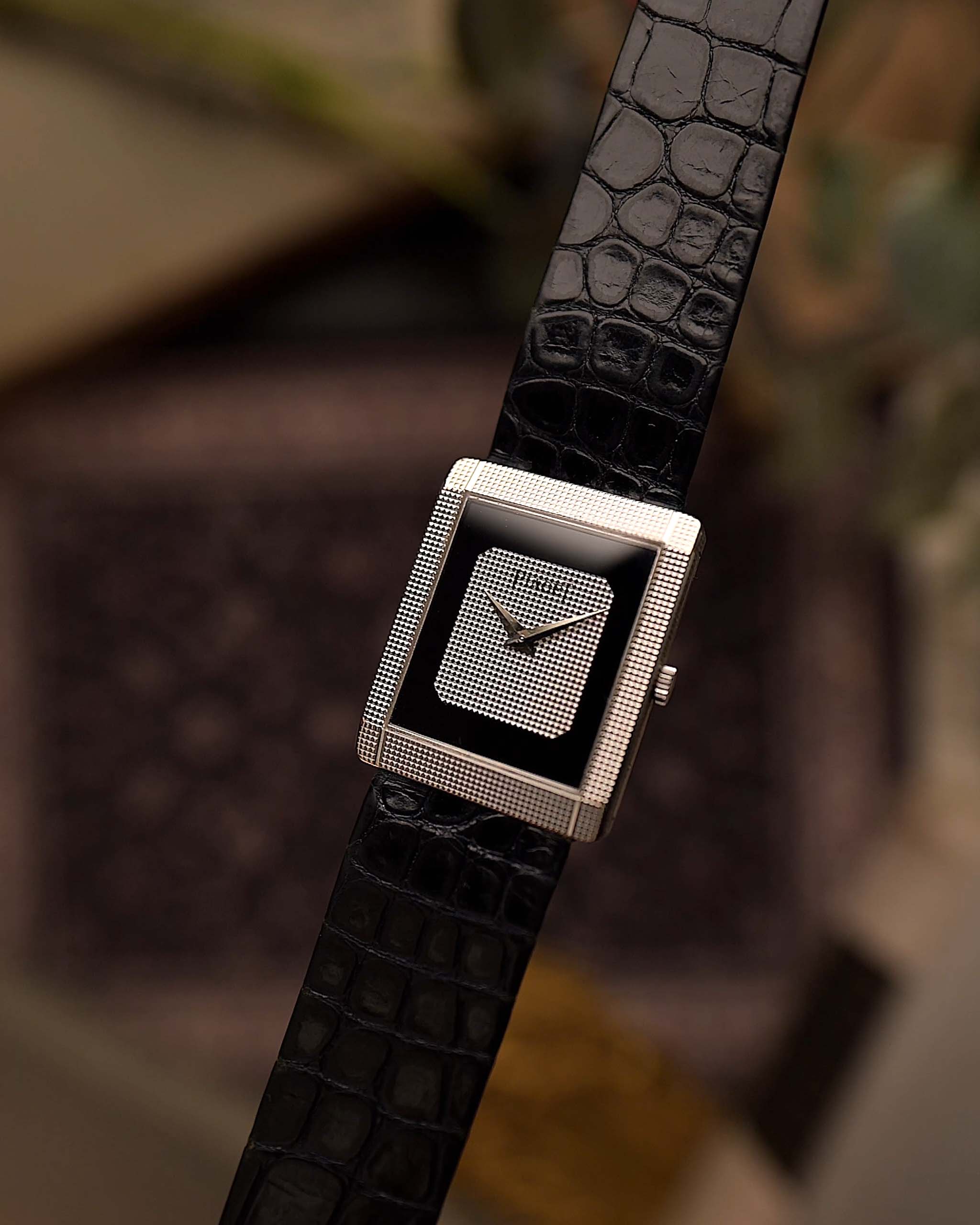 Orologio vintage Piaget Protocole 9151, oro bianco 18 carati, quadrante Onyx, forma a carro armato, movimento Calibro 9P, cinturino in pelle, su sfondo sfocato