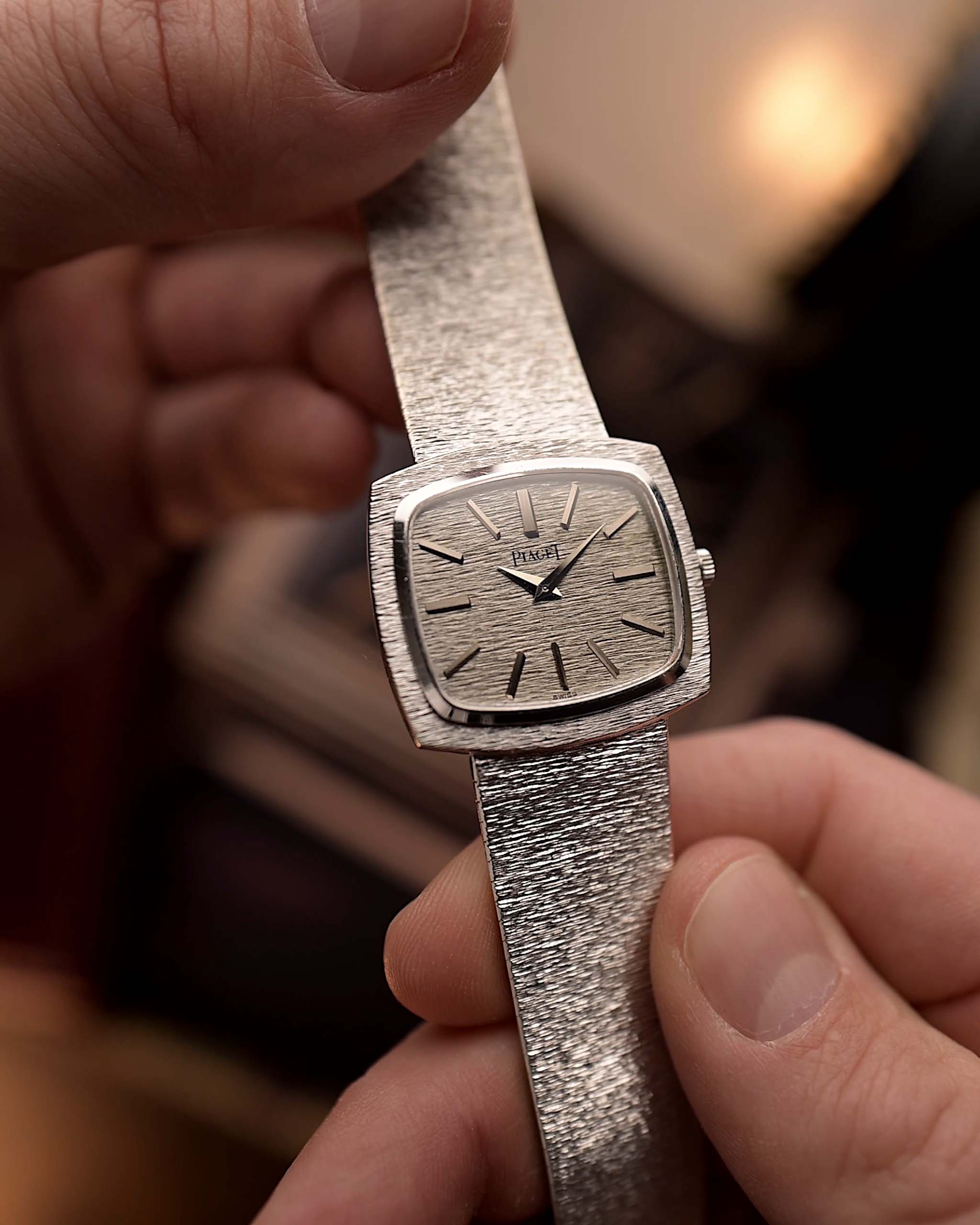 Orologio vintage Piaget TV 9574 in oro bianco 18 carati, raffigurante una corteccia tenuta in una mano con sfondo sfocato.