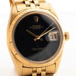 Una foto ravvicinata di un Rolex Datejust 36 mm 1601 Onyx in oro giallo del 1969 su un polso. in oro giallo 18 carati con calibro automatico 157, quadrante originale in onice e bracciale Jubilee.