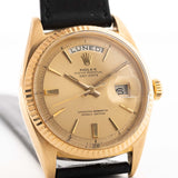 Un primo piano di un Rolex Day Date 1803 Pie Pan vintage del 1966. Oro giallo, Calibro automatico 1556 da 36 m, quadrante dorato con raggi di sole e cinturino in pelle.