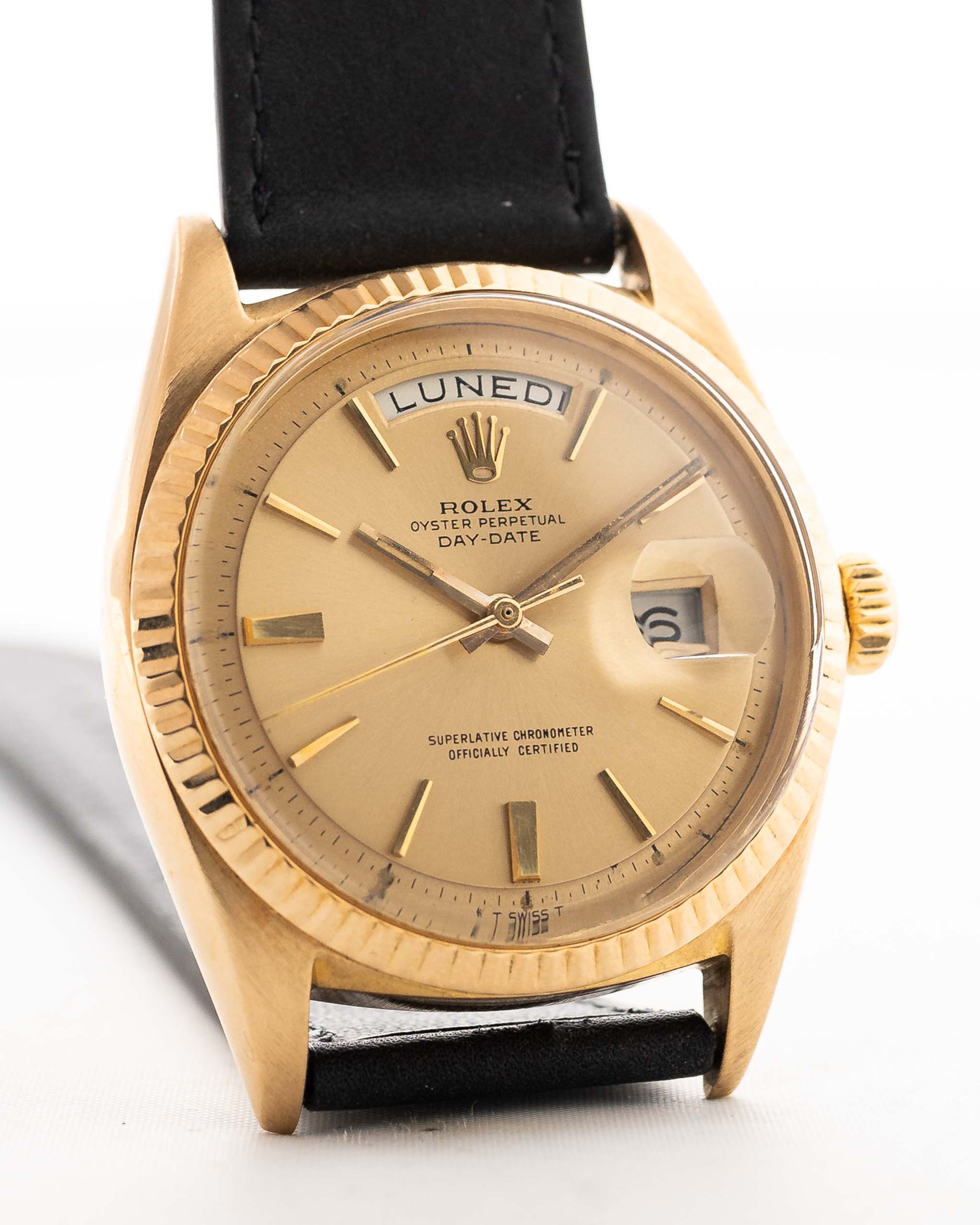 Un primo piano di un Rolex Day Date 1803 Pie Pan vintage del 1966. Oro giallo, Calibro automatico 1556 da 36 m, quadrante dorato con raggi di sole e cinturino in pelle.