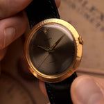 Orologio vintage Rolex Precision 9919 tenuto da una mano su uno sfondo sfocato