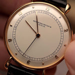Primo piano dell'orologio Vintage Vacheron Constantin Teardrop in oro rosa 18k, quadrante bianco-argento, manuale Cal. V454, su cinturino nero, sfondo sfocato