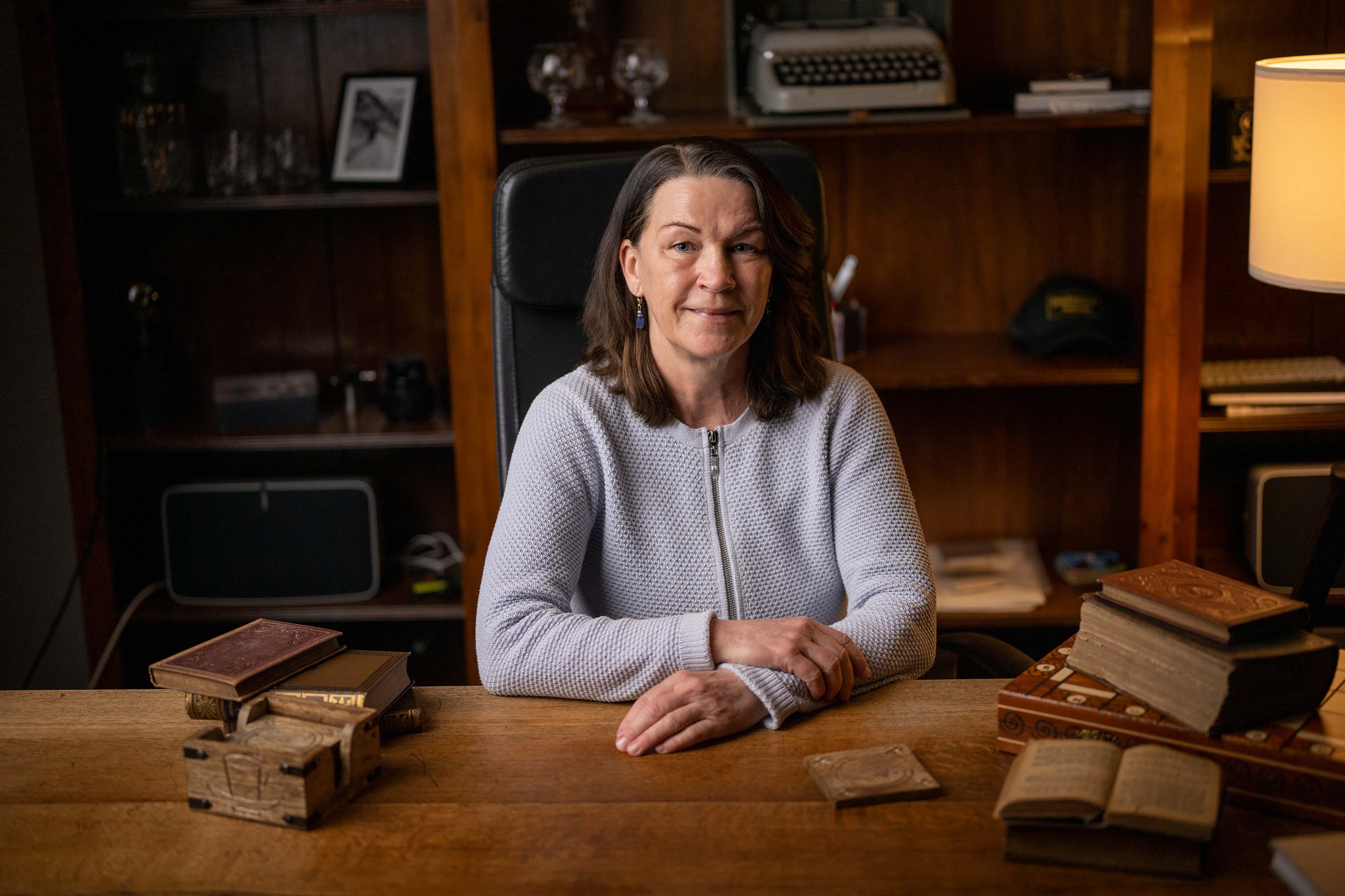 Donna al tavolo di legno con libri.