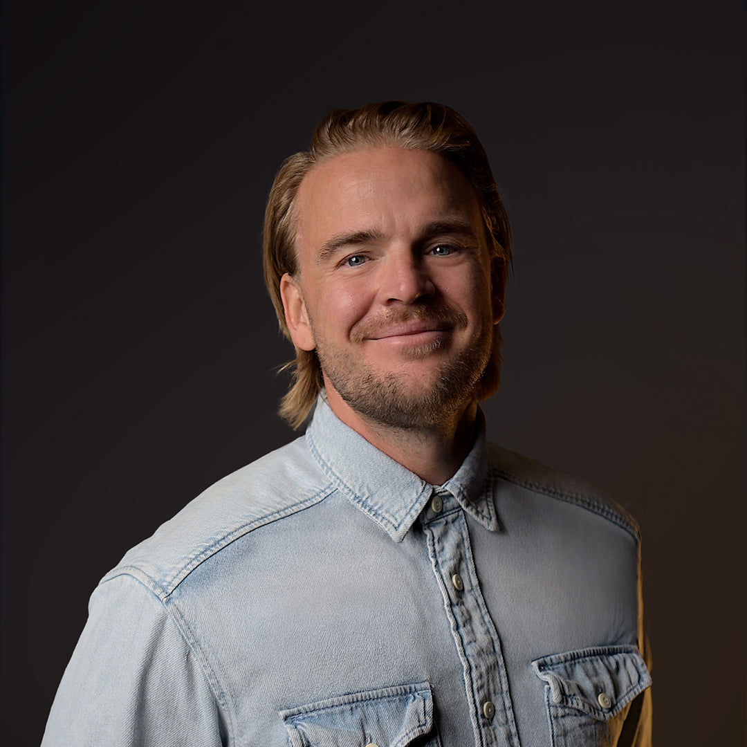 Uomo che indossa una giacca di jeans blu chiaro su uno sfondo scuro