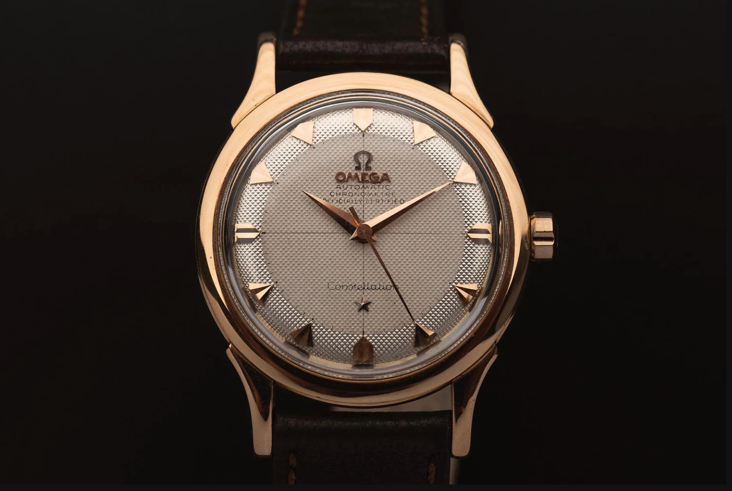 Orologio Omega d'oro con quadrante argento-oro e cinturino in pelle.