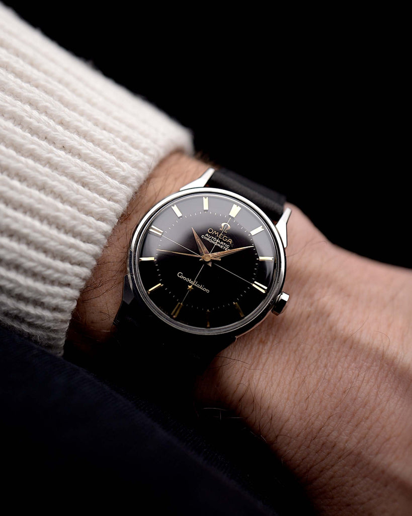 Video di un Omega Constellation 14900 Pie Pan Black del 1961 al polso. Cassa in acciaio da 34 mm con cronometro automatico Calibro 551, quadrante pie pan nero originale e cinturino in pelle.