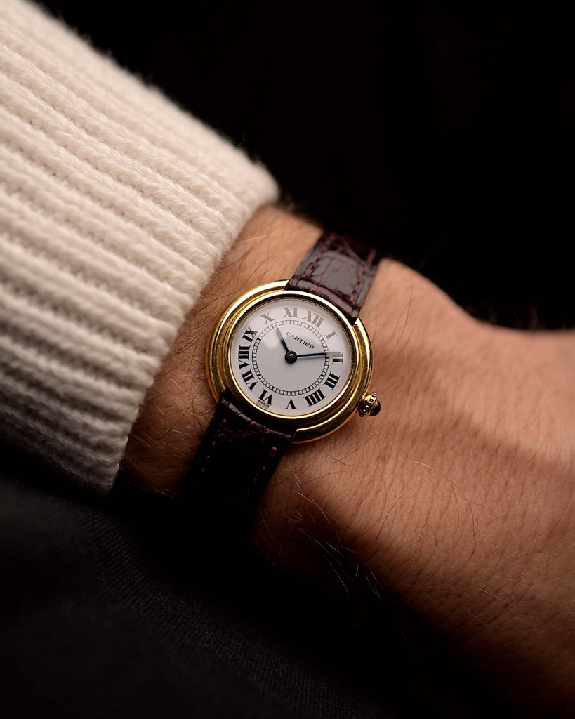 Orologio vintage Cartier Ellipse in oro 18 carati, quadrante bianco firma Paris, cinturino originale in pelle rossa, al polso, sfondo nero