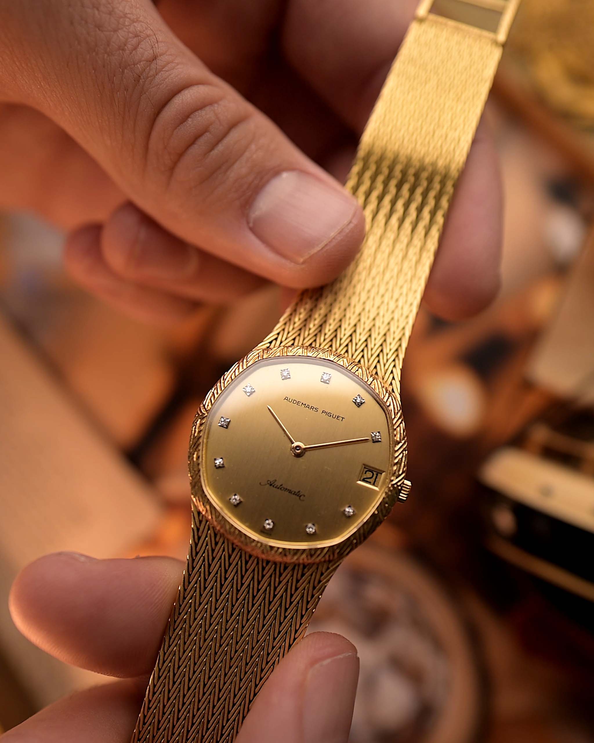 Vintage Audemars Piguet Automatic watch from the 1980s, 31.5mm 18k gold case, gold dial, 11 diamond hour markers on blurred background