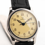 1935 年的 Omega Radium Sword Arabic 腕上特寫照片。28mm 不銹鋼錶殼，配手動上鏈機芯，原裝金色錶盤，鐳射光澤，真皮錶帶。