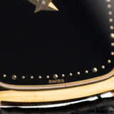 1970 年代 Piaget Tonneau 9691 Onyx 18K 手錶特寫照片。24mm 18K 黃金錶殼、手動上鏈機芯、黑色縞瑪瑙錶盤和原裝黑色真皮錶帶。