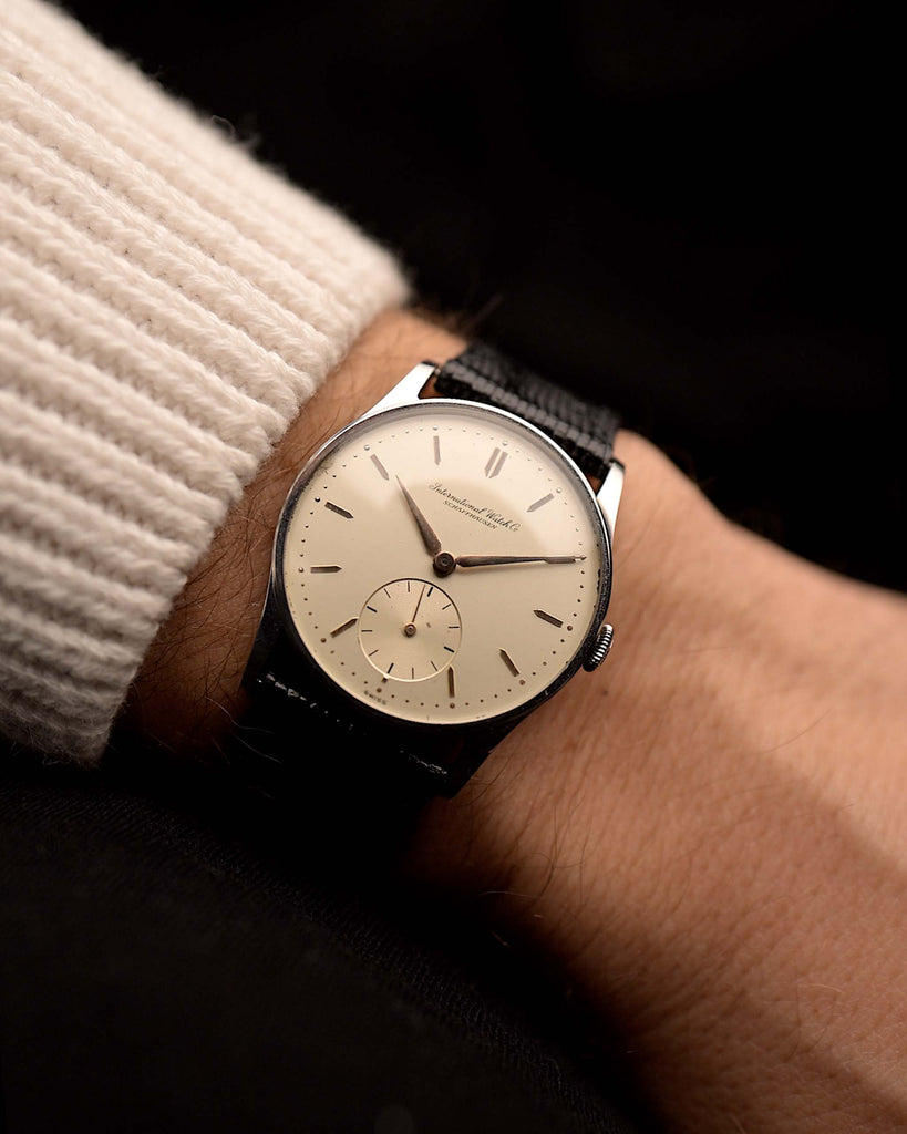 復古IWC萬國錶Cal.1940年製造的83 Sub Second腕錶，搭配黑色皮革錶帶，以深色背景作為襯托。32毫米寬，不銹鋼錶殼，配手動Cal.83機芯、銀色錶盤和黑色皮錶帶。